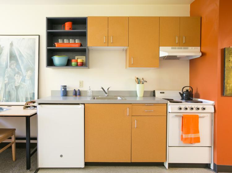 Kitchenette with mini fridge and stove with oven