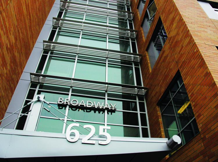 Shot looking up at the class and brick entrance to Broadway Hall