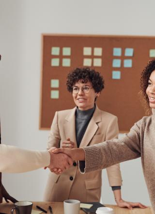 people in a meeting room shaking hands