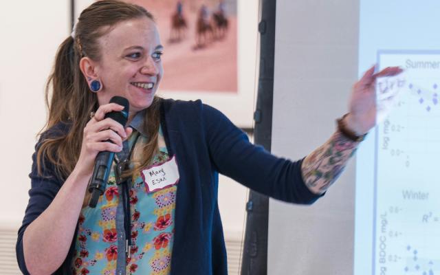 Student Mary Munt points at her data displayed on a projection screen.