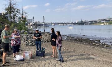 group of people with equipment standing together near the river