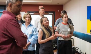 A group of attendees, some wearing name badges, stand together in conversation during the seminar, with a Ukrainian flag visible on the wall.