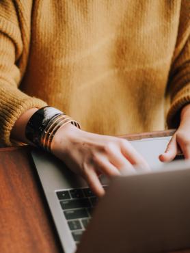 Person's hands typing on laptop keyboard