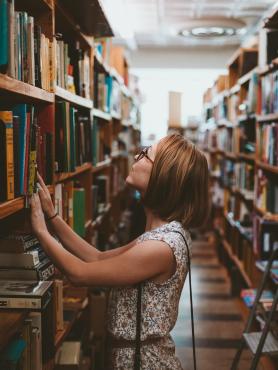 Young student looking at bookshelf