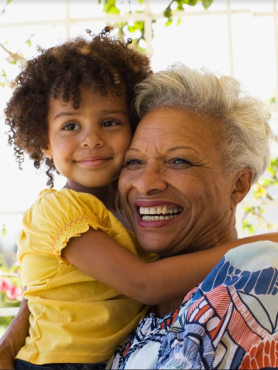 Older woman smiling while holding child