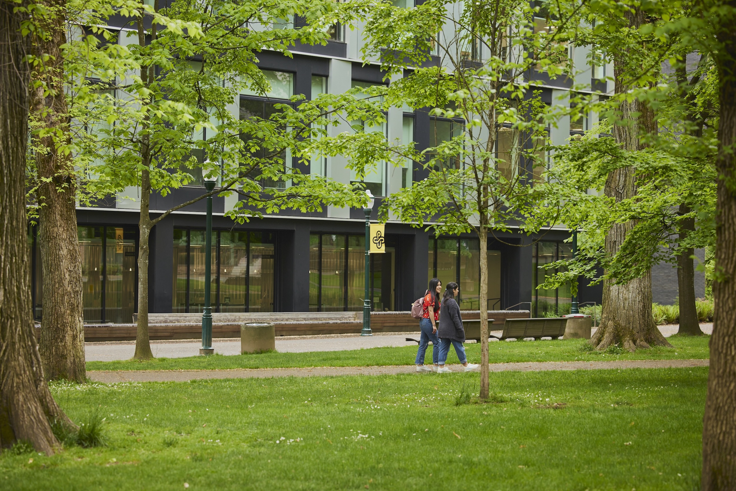 Students walking in Park Blocks with Fariborz Maseeh Hall in background