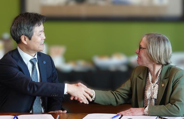 President Ann Cudd shaking hands with a delegate from Seoul