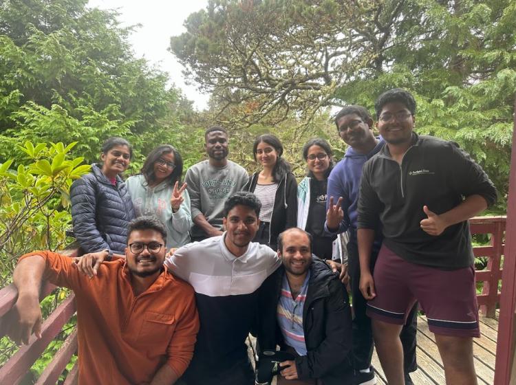 Ten students pose for a group photo outside.