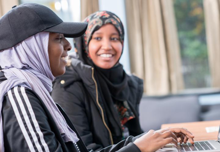 Two students working side by side at a computer