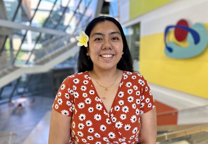Student stands and poses for a headshot in the Karl Miller Center Atrium.