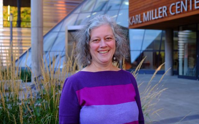 Headshot of Christina Luther standing in front of Karl Miller Center