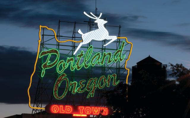 Neon sign that reads Portland Oregon Old Town with reindeer jumping above.