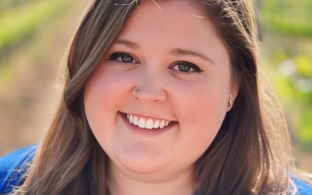 Katie Trencheny, international scholar and faculty advisor standing in front of a nature background
