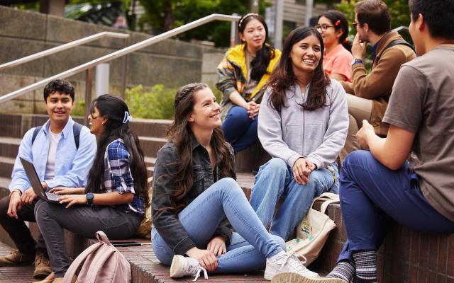 Groups of students sitting outside having a conversations.