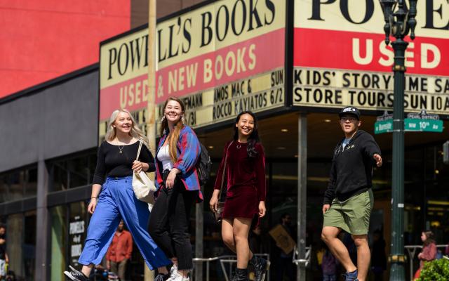 Four students cross the street in front of Powell's Book Store.
