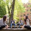 Four students sitting outside and conversing