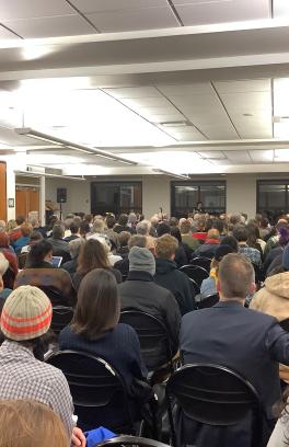 photo from the back of a lecture hall with large audience 