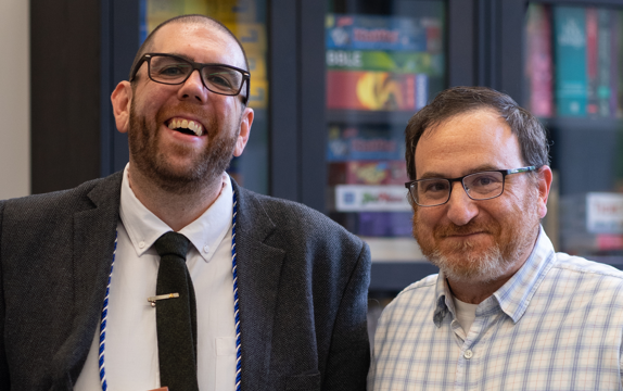 Caring professor stands with graduating student