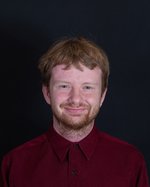 A professional photo of Jared Cutler in a maroon button-up shirt on a black background.
