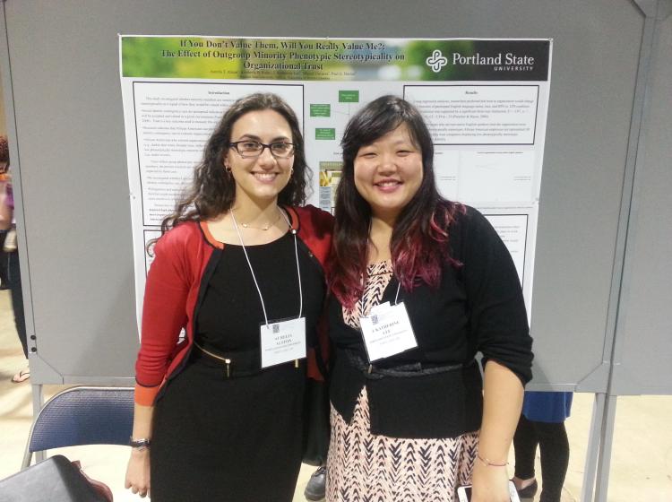 GRASP Lab members Aurelia Alston and  J. Katherine Lee standing in front of an academic poster at SPSP 2015.