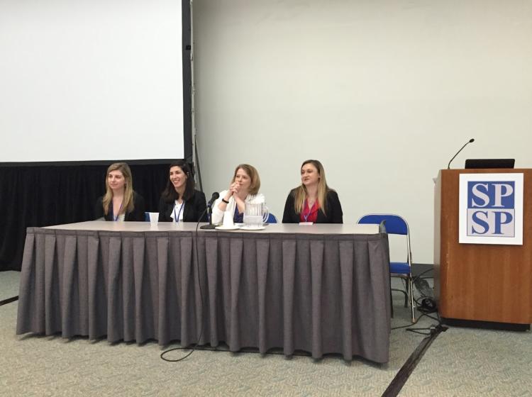 Dr. Kahn sitting next to four other women at a conference table facing an audience participating in a question and answer panel during a symposium. 