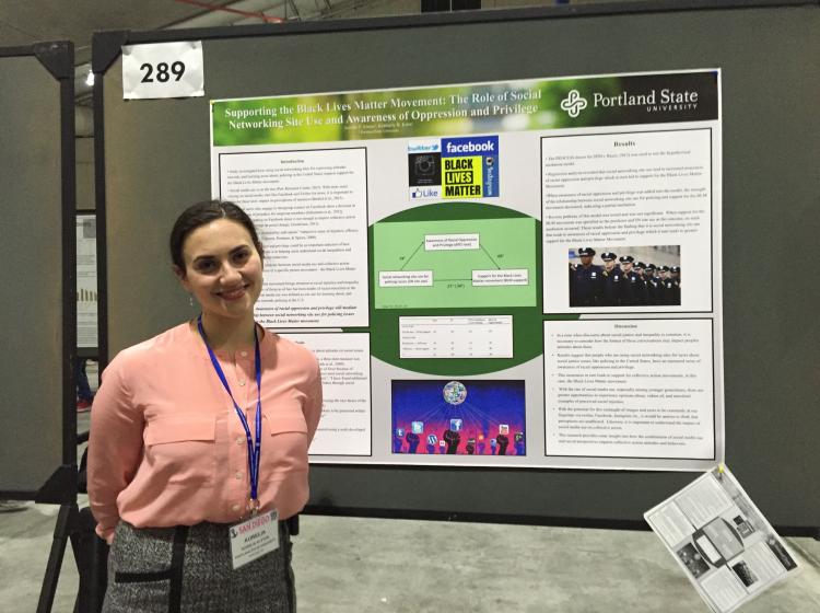 Aurelia Alston standing in front of her poster at SPSP 2016 annual conference. The poster is titled: "Supporting the Black Lives Matter Movement: The Role of Social Networking Site Use and Awareness of Oppression and Privilege"