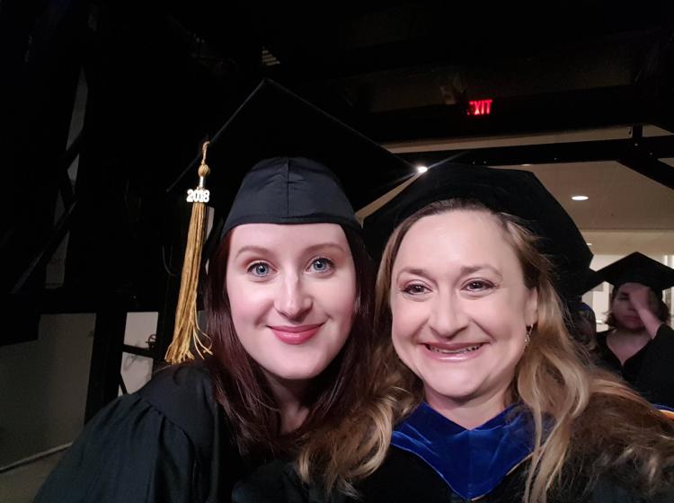 A selfie with Jean McMahon and Kimberly Kahn both wearing graduation gowns for Jean's doctoral graduation.