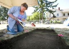 Woman excavates bone from dig site