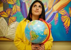 Woman holding globe looking upward