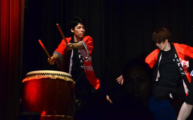 Man in traditional Japanese robe playing drum