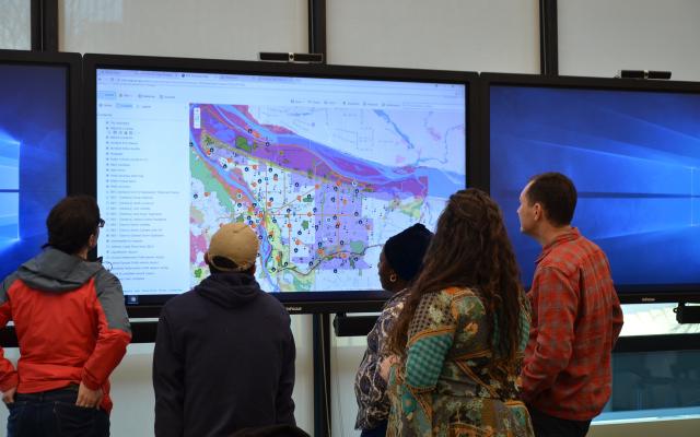 Group of people looking at map displayed on projector