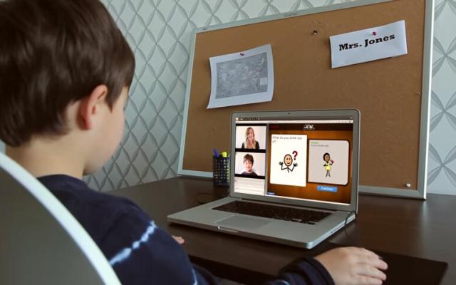 Boy looking at videoconference on laptop, part of teletherapy