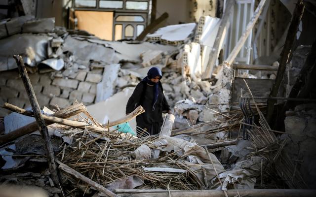 Woman takes in destroyed surroundings in aftermath of earthquake