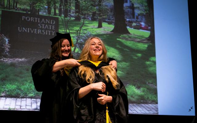 Student being hooded by faculty member at graduation ceremony