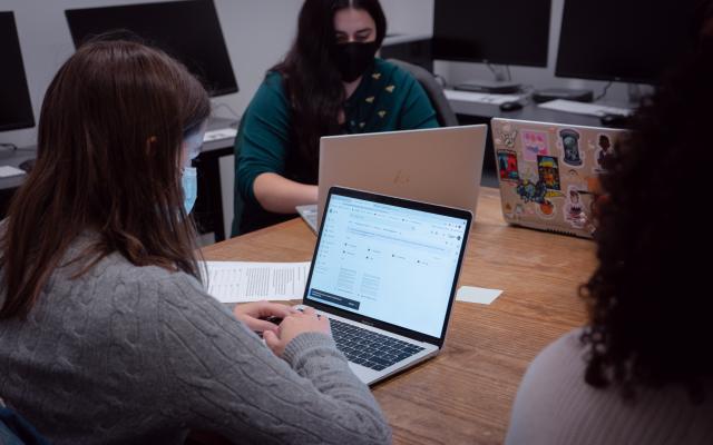 Students around table on laptops