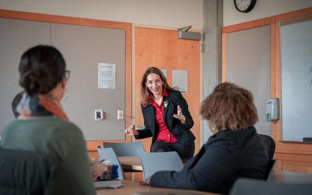 Professor in front of classroom, two students in foreground
