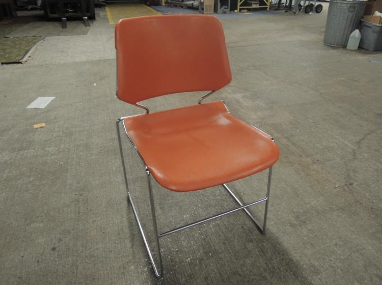 Orange plastic stacking chair