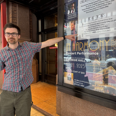 Francis Upton V points to Carnegie Hall poster