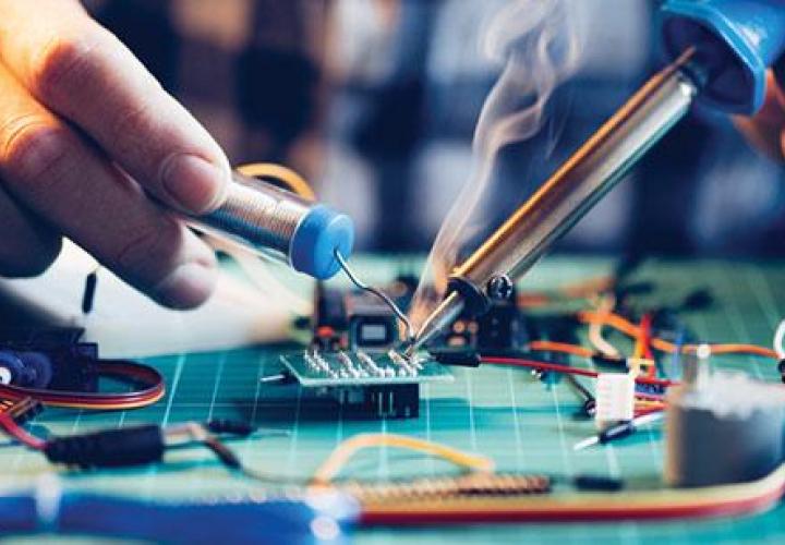 person soldering circuit board