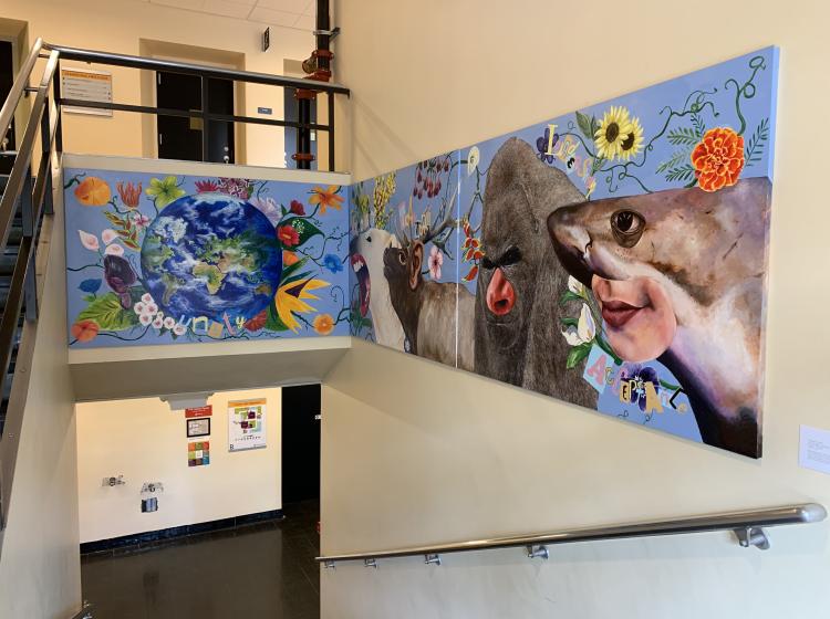 Section of the mural on three contiguous panels, depicting the earth surrounded by flowers, and more animal hybrids with human features.