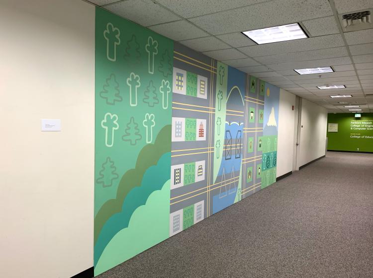 A long floor-to-ceiling mural in a carpeted hallway. The mural is a stylized depiction of Portland with trees, buildings, streets and river.