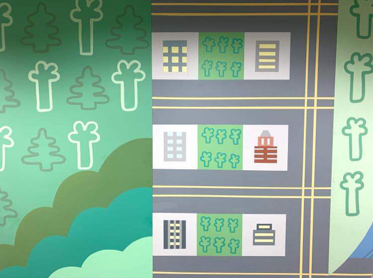 Close-up of the mural, showing trees and hills at left and buildings on a street grid at right.