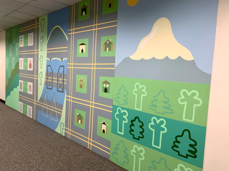 The mural is seen from the far right end, which features Mt. Hood.