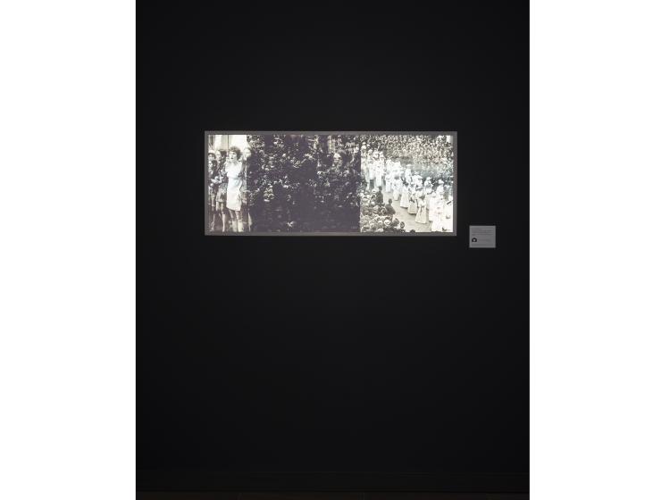 The framed photo is shown, lit only by a photographic flash. It now looks black and white, and people are clearly visible in the imagery.