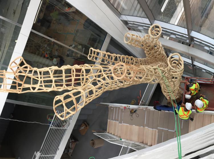 View from above as the sculpture is installed by a team of workers in reflective gear.