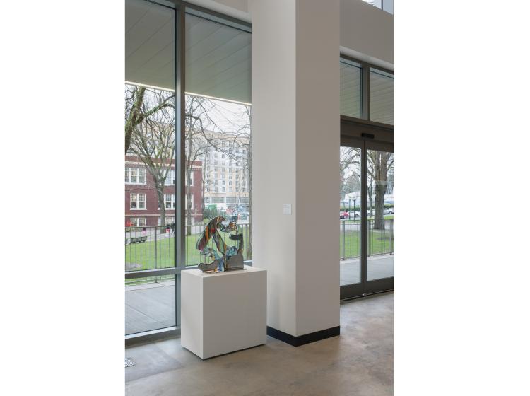 The atrium of Peter Stott Center is seen, with the sculpture sitting on a short white pedestal.