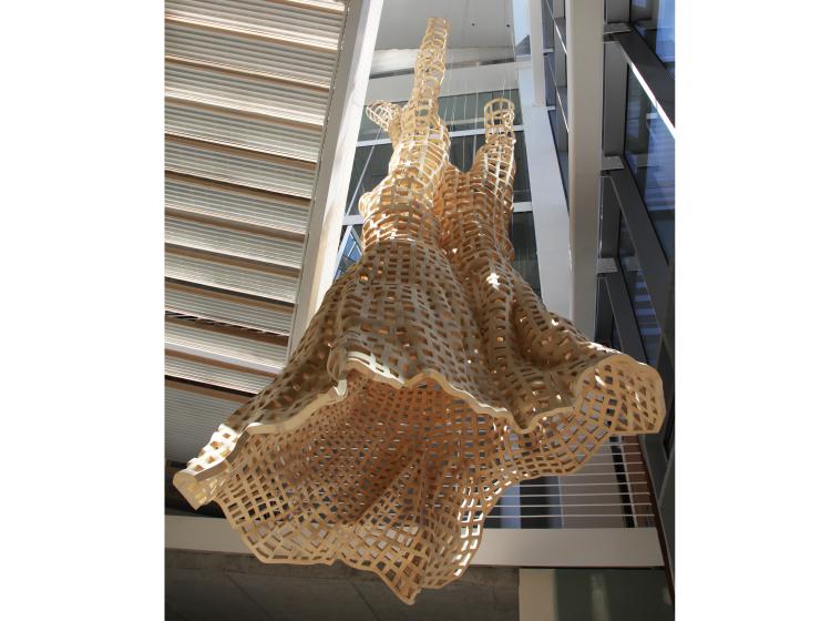 Suspended above the floor of the Karl Miller Center atrium is a large, hollow wooden sculpture in the shape of a bristlecone pine tree, here seen from below.