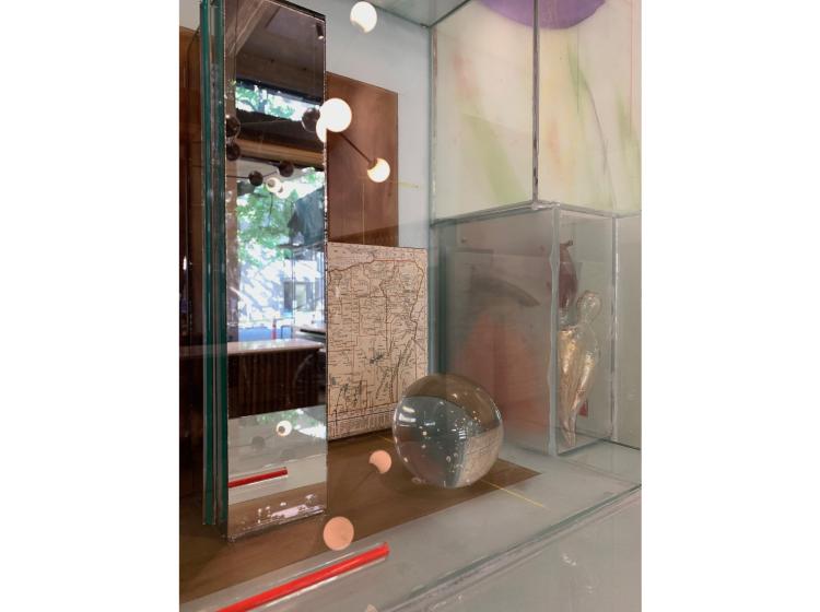 Detail shot of a section of the artwork, which includes a map of Oregon, a mirrored section and a clear glass ball