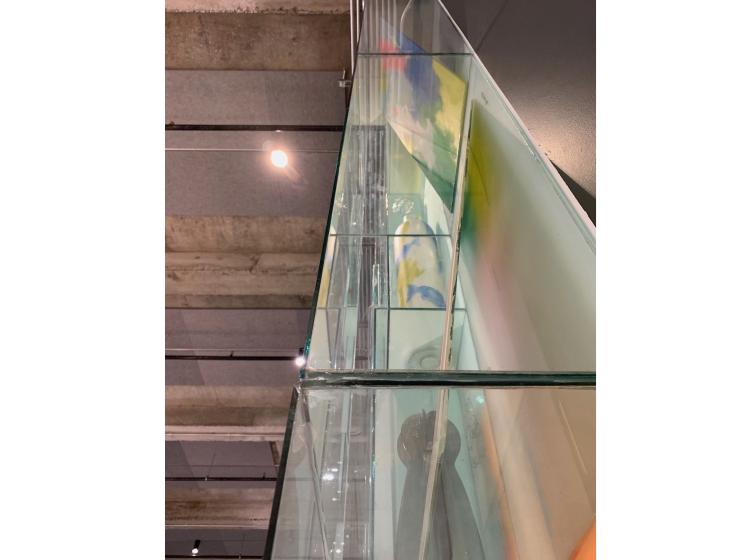 The artwork is seen at a dramatic angle looking up along the edge of it