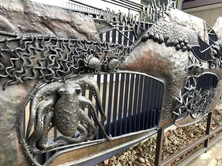 A close-up view of a section of the sculpture, depicting an octopus and shoreline